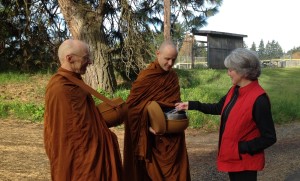 photo: White Salmon resident Kathy Kacena offering food on the morning alms round.
